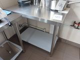 une table en acier inoxydable sur laquelle sont posés des casseroles et des poêles