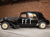 a black car parked in front of a brick wall