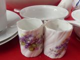 three cups and a saucer on a table with a red table cloth