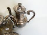 trois théières en argent posées sur une table blanche
