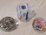 trois objets en verre posés les uns à côté des autres sur une table