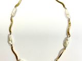 un gros plan d'un collier sur une surface blanche avec un fond blanc