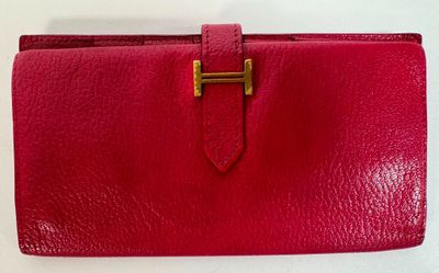 a red leather wallet with a gold clasp on it