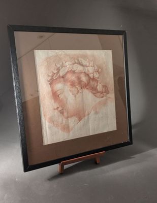 tableau représentant la tête d'une femme, dans un cadre noir, posé sur un socle