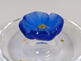 a glass bowl with a blue flower in it