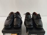 two pairs of black shoes sitting on top of a black box