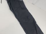 un pantalon cargo noir posé sur une surface blanche