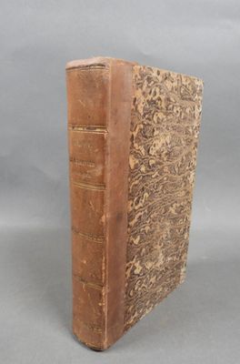 an old book sitting on top of a table next to a gray background
