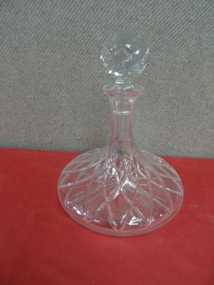 a glass vase with a flower on it on a red surface