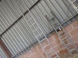 several ladders are leaning against a wall in an industrial building