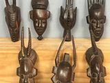 six masques africains en bois fixés sur un mur en bois