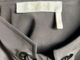 a close up of the back of a grey jacket with a white label on it