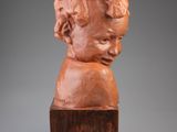 a sculpture of a child ' s head on a wooden block