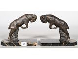 une paire de sculptures en bronze représentant deux chiens, posées sur des socles en marbre