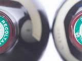 two bottles of wine sitting next to each other on a table