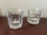 two glasses sitting on a table next to each other