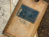 an old book laying on top of a map on the ground