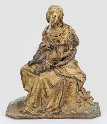 une statue en bronze d'une femme assise sur un rocher