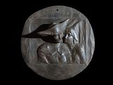 a bronze plaque of a man and a woman on a black background