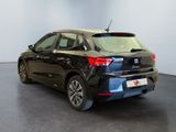 the rear of a black car is parked in a showroom