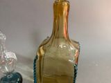 a small glass bottle with a glass stopper next to it