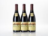 three bottles of red wine sitting next to each other on a table