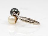 an image of a black and white pearl ring on a white surface