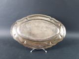 an antique silver plate on a stand on a black background