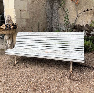 a white bench sitting in front of a stone building
