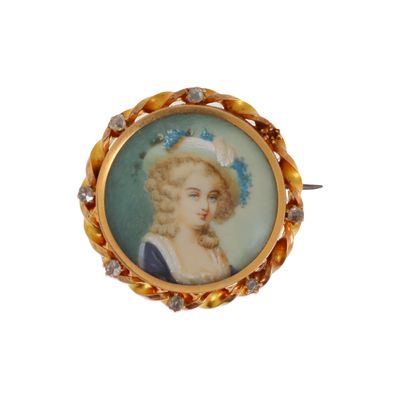 portrait d'une femme en robe bleue, une fleur dans les cheveux, sur une broche en or