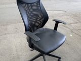 une chaise de bureau noire posée au milieu de la pièce