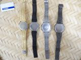 three watches sitting on top of a wooden table next to a tag