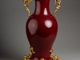 a large red vase with gold decoration on it