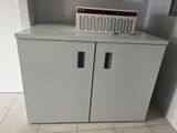 une armoire blanche à deux portes, surmontée d'une pancarte