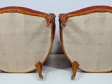 pair of antique chairs with upholstered back cushions and wooden legs