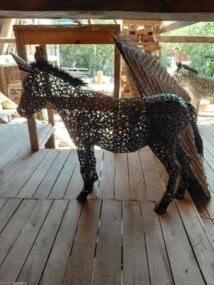 a horse made out of wire on a wooden floor