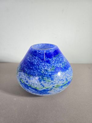 un vase en verre bleu et vert posé sur une table