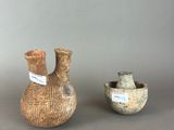 two small vases sitting next to each other on a table