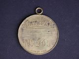 a close up of a silver medal on a blue surface