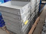 une grande pile de caisses posée sur une palette dans un entrepôt