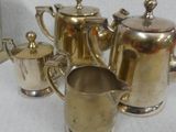a silver plated tea set on a white table
