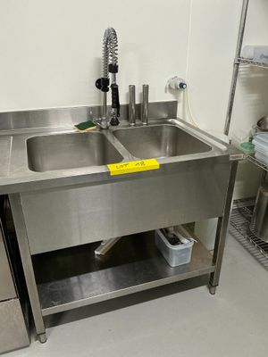 un évier en acier inoxydable au milieu d'une cuisine