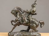 bronze statue of a man on a horse with a bird on his back