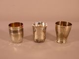 three silver cups sitting on top of a table next to each other