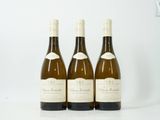 trois bouteilles de vin posées sur une table blanche