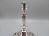 a silver plated candle holder on a grey background