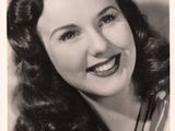 an old black and white photo of a woman with a smile on her face