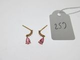 une paire de boucles d'oreilles roses et dorées avec une étiquette de prix