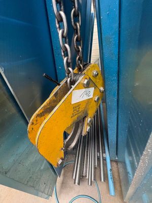 une grue jaune suspendue au flanc d'un immeuble bleu