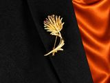 a close up of a gold flower brooch on a black suit